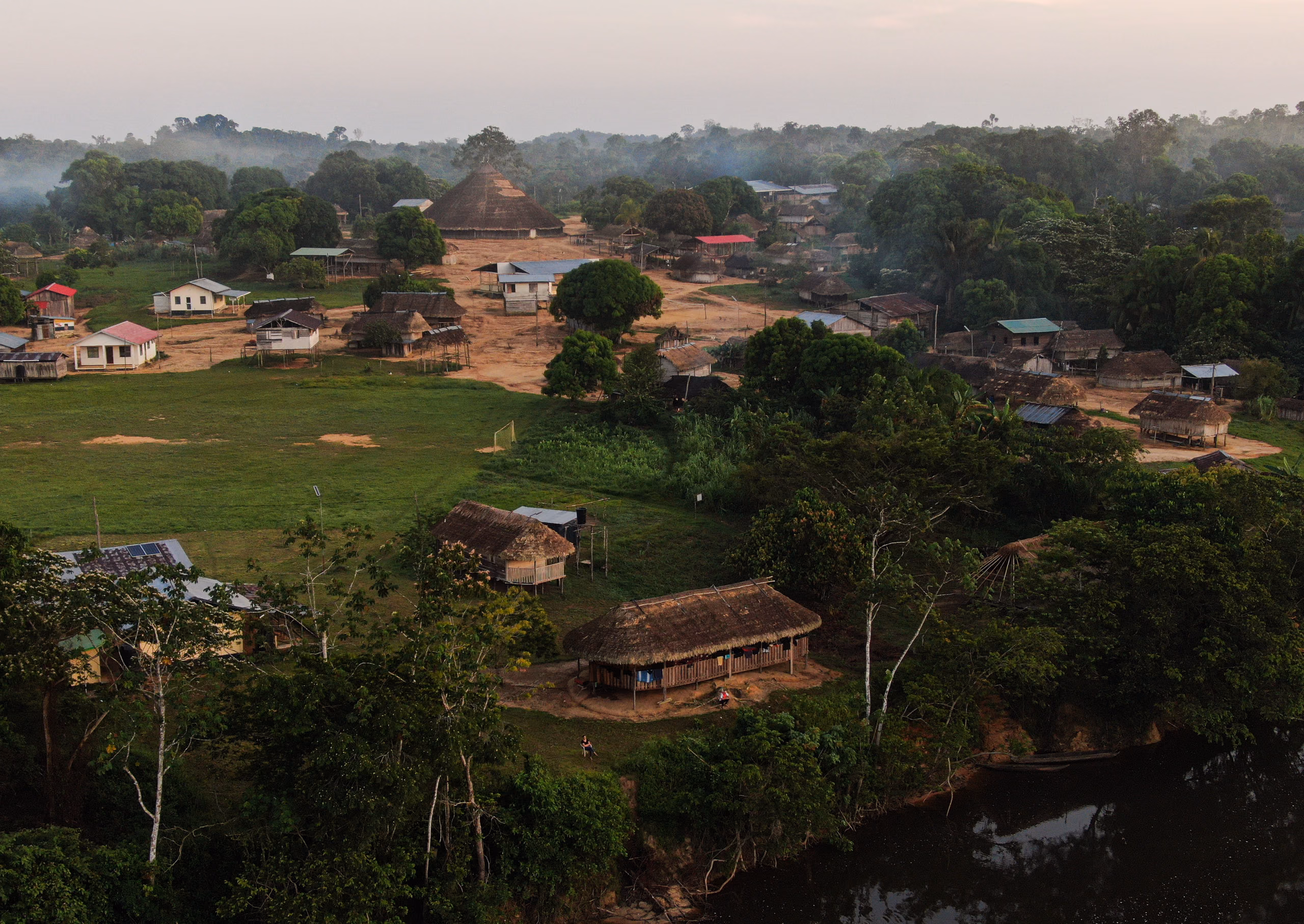 Kwamalasamutu seen from the air, its buildings spread along a clearing in the rainforest